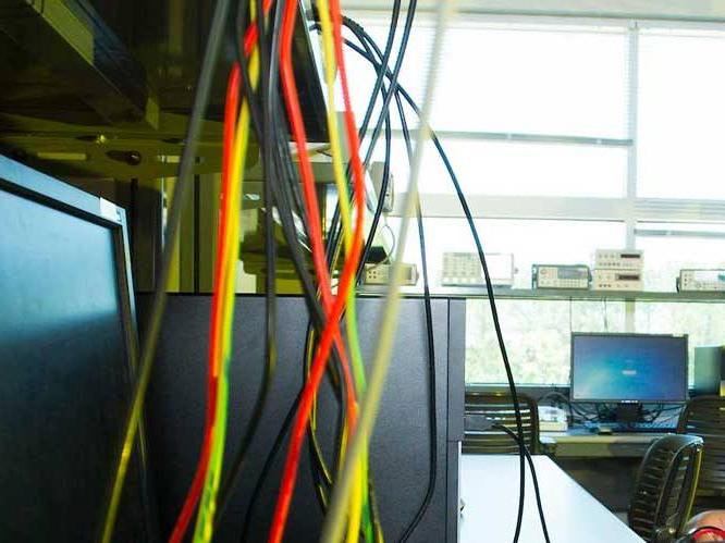 Computer wires hanging down in front of a computer monitor