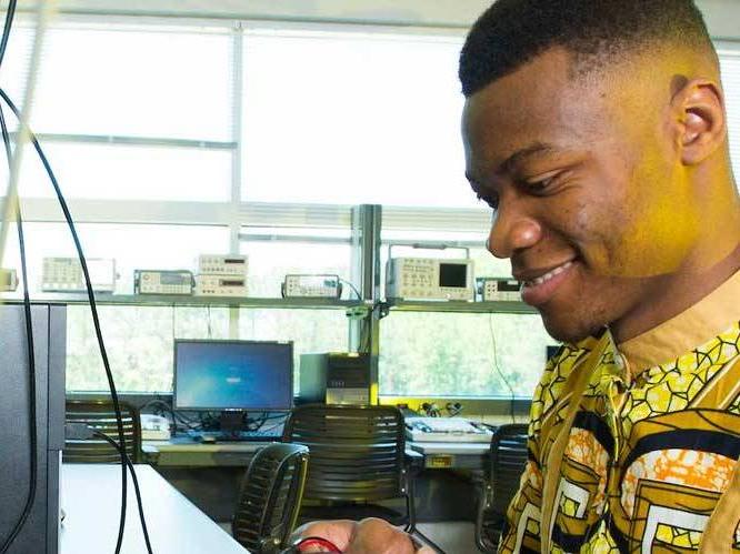 Man is looking down at a computer monitor with a wire hanging infront of it